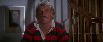 Movie still from “The Deep” (1977), directed by Peter Yates – A person with a mustache wearing a striped shirt; Close Up shot, Low angle