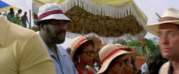 Movie still from “The Deep” (1977), directed by Peter Yates – A man and two women wearing hats under an umbrella; Close Up shot, Low angle