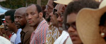 Movie still from “The Deep” (1977), directed by Peter Yates – A group of men sitting next to each other; Close Up shot, Low angle