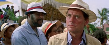 Movie still from “The Deep” (1977), directed by Peter Yates – A group of people standing under an umbrella; Close Up shot, Over the shoulder angle