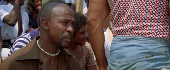 Movie still from “The Deep” (1977), directed by Peter Yates – A group of people standing next to each other on a beach; Close Up shot, Low angle