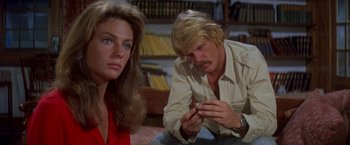 Movie still from “The Deep” (1977), directed by Peter Yates – A man and a woman looking at something on a table; Close Up shot, High angle