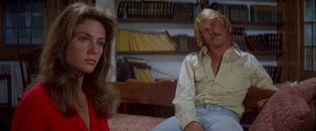 Movie still from “The Deep” (1977), directed by Peter Yates – A man and a woman sitting on a bed in front of a bookshelf; Close Up shot, Over the shoulder angle
