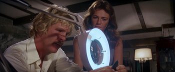 Movie still from “The Deep” (1977), directed by Peter Yates – A man and a woman are looking at a clock; Close Up shot, Low angle