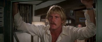 Movie still from “The Deep” (1977), directed by Peter Yates – A man with long blonde hair and a mustache; Close Up shot, Low angle