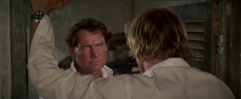 Movie still from “The Deep” (1977), directed by Peter Yates – A man looking at himself in the mirror; Close Up shot, Over the shoulder angle