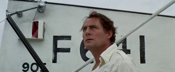 Movie still from “The Deep” (1977), directed by Peter Yates – A person wearing a white shirt; Close Up shot, Low angle