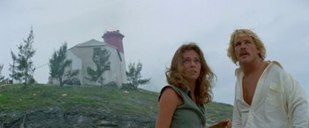 Movie still from “The Deep” (1977), directed by Peter Yates – A woman standing in front of a light house; Medium shot, Low angle