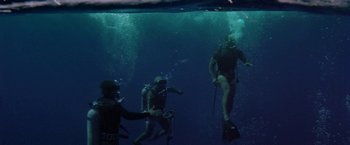 Movie still from “The Deep” (1977), directed by Peter Yates – A group of scuba divers swimming under the water; Wide shot, High angle