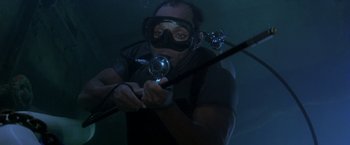 Movie still from “The Deep” (1977), directed by Peter Yates – A man in a scuba mask holding a fishing rod; Medium shot, High angle