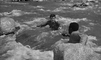 Movie still from “The Defiant Ones” (1958), directed by Stanley Kramer – Two men in the water holding hands while one is in the water; Medium shot, High angle