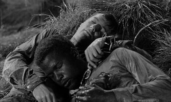 Movie still from “The Defiant Ones” (1958), directed by Stanley Kramer – Two men are laying on the ground in the grass; Close Up shot, High angle