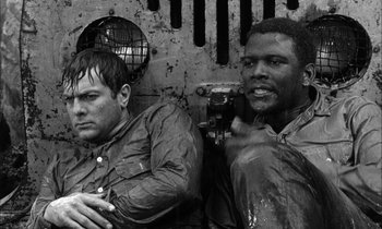 Movie still from “The Defiant Ones” (1958), directed by Stanley Kramer – A black and white photo of two men sitting next to each other; Close Up shot, Low angle