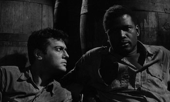 Movie still from “The Defiant Ones” (1958), directed by Stanley Kramer – A black and white photo of two men sitting next to each other; Close Up shot, Low angle