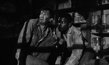 Movie still from “The Defiant Ones” (1958), directed by Stanley Kramer – A black and white photo of two men sitting next to each other; Medium shot, Low angle