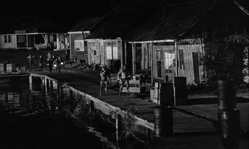 Movie still from “The Defiant Ones” (1958), directed by Stanley Kramer – A black and white photo of people on a dock; Extreme Wide shot, High angle