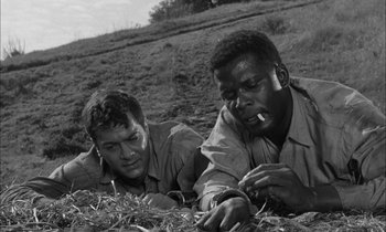 Movie still from “The Defiant Ones” (1958), directed by Stanley Kramer – A black and white photo of two men laying in the grass; Close Up shot, Low angle