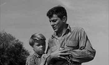 Movie still from “The Defiant Ones” (1958), directed by Stanley Kramer – A man and a young boy looking at each other; Medium shot, Low angle