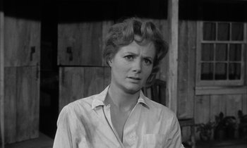 Movie still from “The Defiant Ones” (1958), directed by Stanley Kramer – Black and white photograph of a woman in front of a barn; Close Up shot, Low angle