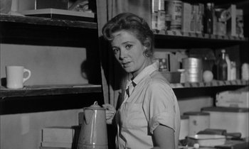Movie still from “The Defiant Ones” (1958), directed by Stanley Kramer – A black - and - white photo of a woman holding a coffee pot; Medium shot, Low angle