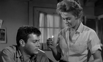 Movie still from “The Defiant Ones” (1958), directed by Stanley Kramer – A man and a woman are smoking a cigarette together; Close Up shot, Low angle