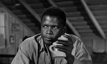 Movie still from “The Defiant Ones” (1958), directed by Stanley Kramer – A black and white photo of a man holding a coffee mug; Close Up shot, Low angle