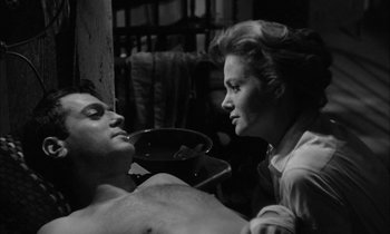 Movie still from “The Defiant Ones” (1958), directed by Stanley Kramer – A man and a woman are sitting in a room; Close Up shot, Low angle