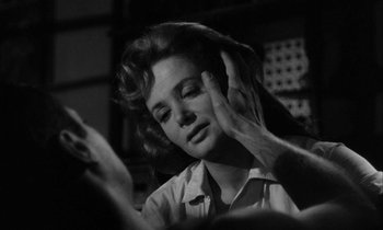 Movie still from “The Defiant Ones” (1958), directed by Stanley Kramer – A black - and - white photo of a woman looking at her phone; Close Up shot, Over the shoulder angle