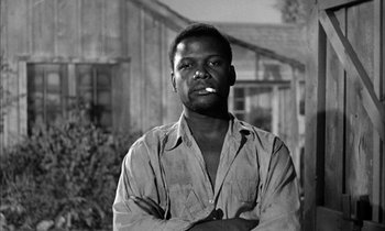 Movie still from “The Defiant Ones” (1958), directed by Stanley Kramer – A black and white photo of a man with his arms crossed; Close Up shot, Low angle
