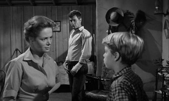 Movie still from “The Defiant Ones” (1958), directed by Stanley Kramer – A black and white photo of a man and a woman and a boy; Medium shot, Over the shoulder angle