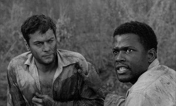 Movie still from “The Defiant Ones” (1958), directed by Stanley Kramer – A black and white photo of two men fighting in a field; Close Up shot, Over the shoulder angle