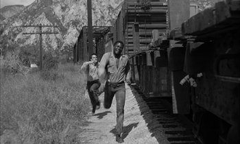Movie still from “The Defiant Ones” (1958), directed by Stanley Kramer – Two men running down the side of a train track; Wide shot, High angle