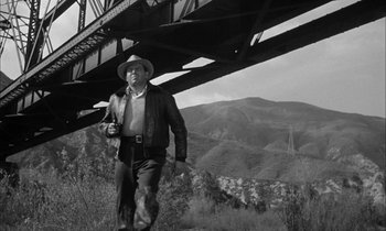 Movie still from “The Defiant Ones” (1958), directed by Stanley Kramer – A black and white photo of a man in a cowboy hat; Wide shot, Low angle