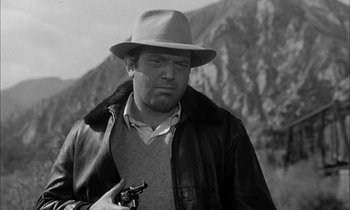 Movie still from “The Defiant Ones” (1958), directed by Stanley Kramer – A black and white photo of a man with a hat and a gun; Close Up shot, Low angle