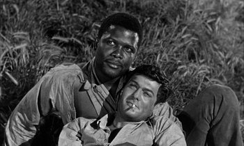 Movie still from “The Defiant Ones” (1958), directed by Stanley Kramer – A black and white photo of two men sitting next to each other; Close Up shot, Over the shoulder angle