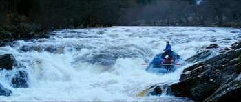 Movie still from “The Descent” (2005), directed by Neil Marshall – A group of people in a raft on a body of water; Extreme Wide shot, High angle