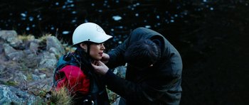 Movie still from “The Descent” (2005), directed by Neil Marshall – A man helping a woman put on a helmet; Close Up shot, Over the shoulder angle