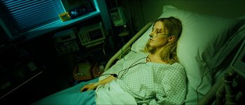 Movie still from “The Descent” (2005), directed by Neil Marshall – A woman laying in a hospital bed while wearing an oxygen mask; Medium shot, High angle