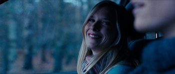 Movie still from “The Descent” (2005), directed by Neil Marshall – A young woman smiles while sitting in a car; Close Up shot, Low angle