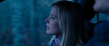 Movie still from “The Descent” (2005), directed by Neil Marshall – A beautiful blonde haired woman looking out a window; Close Up shot, Over the shoulder angle