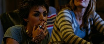 Movie still from “The Descent” (2005), directed by Neil Marshall – A woman smoking a cigarette while sitting at a table; Close Up shot, Over the shoulder angle