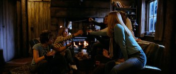 Movie still from “The Descent” (2005), directed by Neil Marshall – A group of people sitting in front of a fire place; Wide shot, High angle