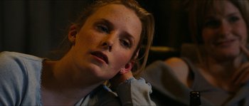 Movie still from “The Descent” (2005), directed by Neil Marshall – A woman with a piercing is sitting in a chair; Close Up shot, Over the shoulder angle