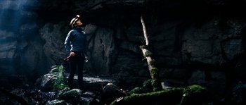 Movie still from “The Descent” (2005), directed by Neil Marshall – A man standing next to a tree in a cave; Wide shot, Low angle