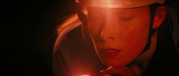 Movie still from “The Descent” (2005), directed by Neil Marshall – A woman's face with a candle in her hand; Extreme Close Up shot, Overhead angle