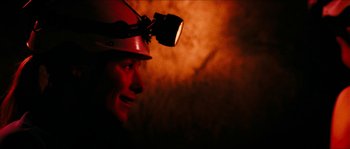 Movie still from “The Descent” (2005), directed by Neil Marshall – A man wearing a hard hat with a light on his head; Close Up shot, Over the shoulder angle
