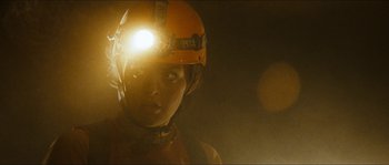 Movie still from “The Descent” (2005), directed by Neil Marshall – A person with a helmet on and a light on; Close Up shot, Low angle