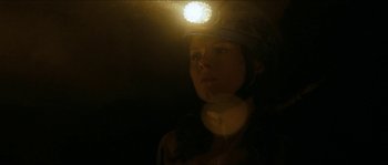 Movie still from “The Descent” (2005), directed by Neil Marshall – A woman with a helmet on her head; Close Up shot, Low angle