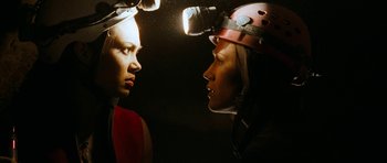 Movie still from “The Descent” (2005), directed by Neil Marshall – Two people wearing hard hats looking into each other's eyes; Close Up shot, Overhead angle