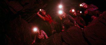 Movie still from “The Descent” (2005), directed by Neil Marshall – A group of people in a cave with headlamps on; Wide shot, Low angle